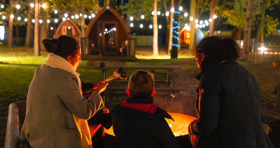 Toasting marshmallows by the firepit at Pinewood glamping pods at Port Lympne Hotel & Reserve in Kent, UK