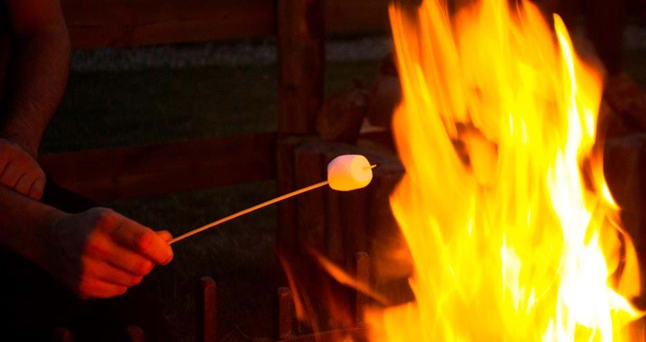 Toasting marshmallows at Bear Lodge glamping at Port Lympne Hotel and Reserve in Kent