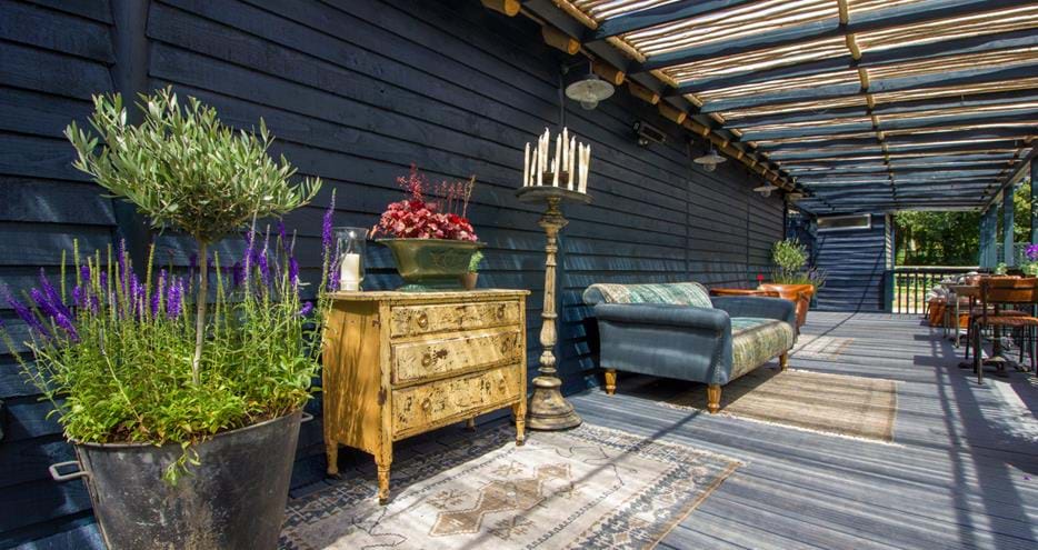 Enjoy a glass of prosecco in comfort on the verandah at Babydoll's Wood Fired Pizza at Port Lympne Hotel and Reserve in Kent