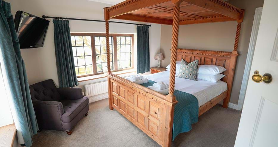 Four poster bed at Giraffe Cottage safari getaway at Port Lympne Hotel & Reserve in Kent