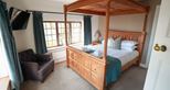 Four poster bed at Giraffe Cottage safari getaway at Port Lympne Hotel & Reserve in Kent